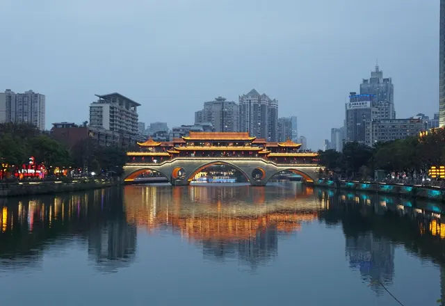 Illuminated Anshun Bridge reflected in the Jin River at dusk in Chengdu