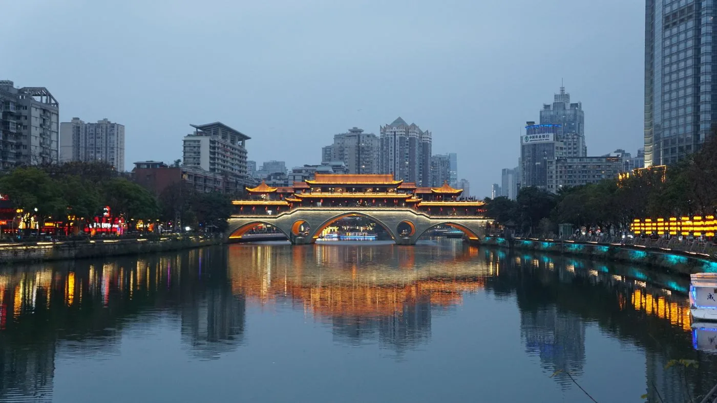 Illuminated Anshun Bridge reflected in the Jin River at dusk in Chengdu