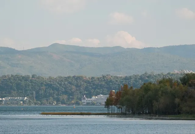 Boats and lakeside trees on Erhai Lake with the mountains beyond, Dali, Yunnan