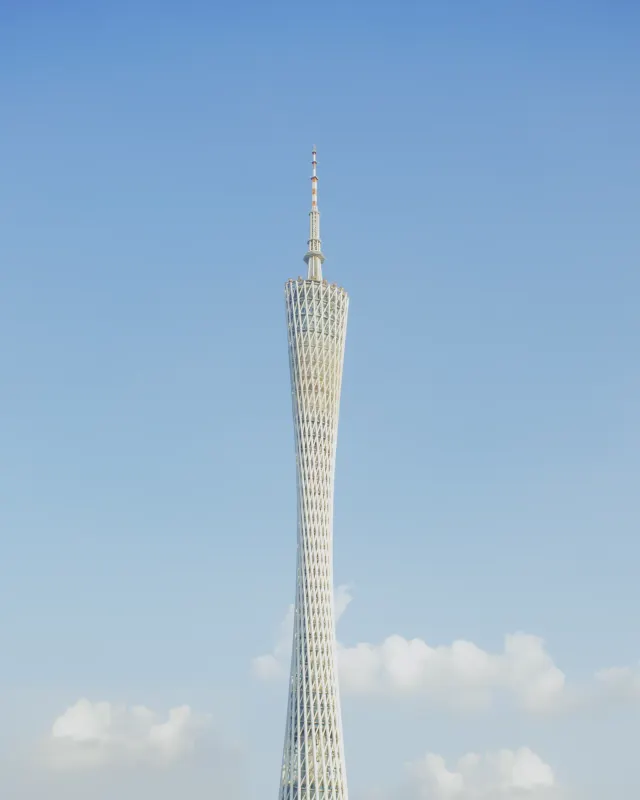 The twisting lattice of Canton Tower against a clear blue sky in Guangzhou