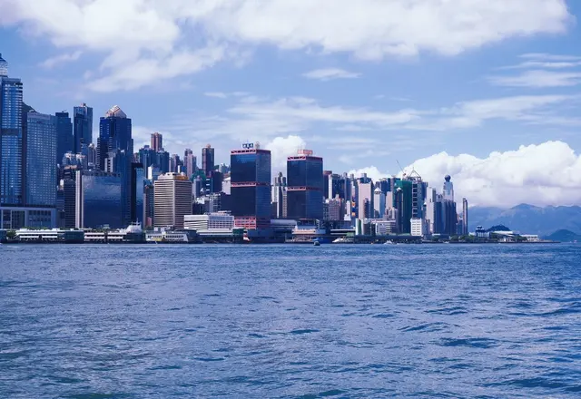 The Hong Kong Island skyline seen across the blue water of Victoria Harbour