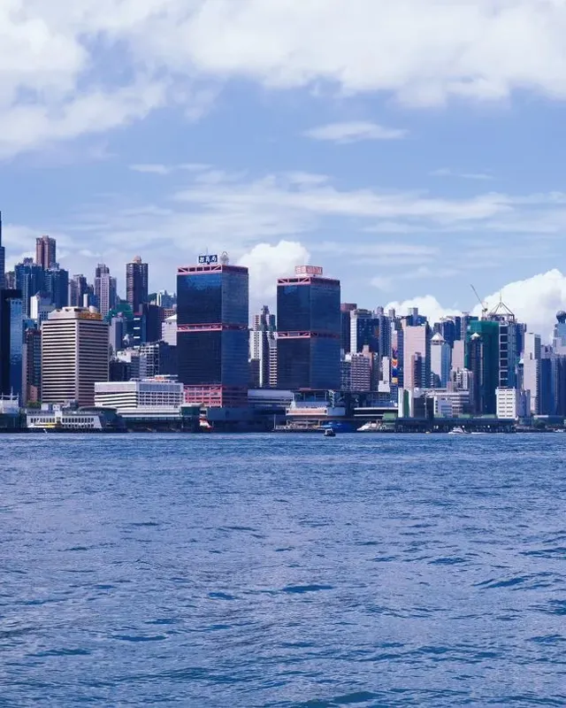 The Hong Kong Island skyline seen across the blue water of Victoria Harbour