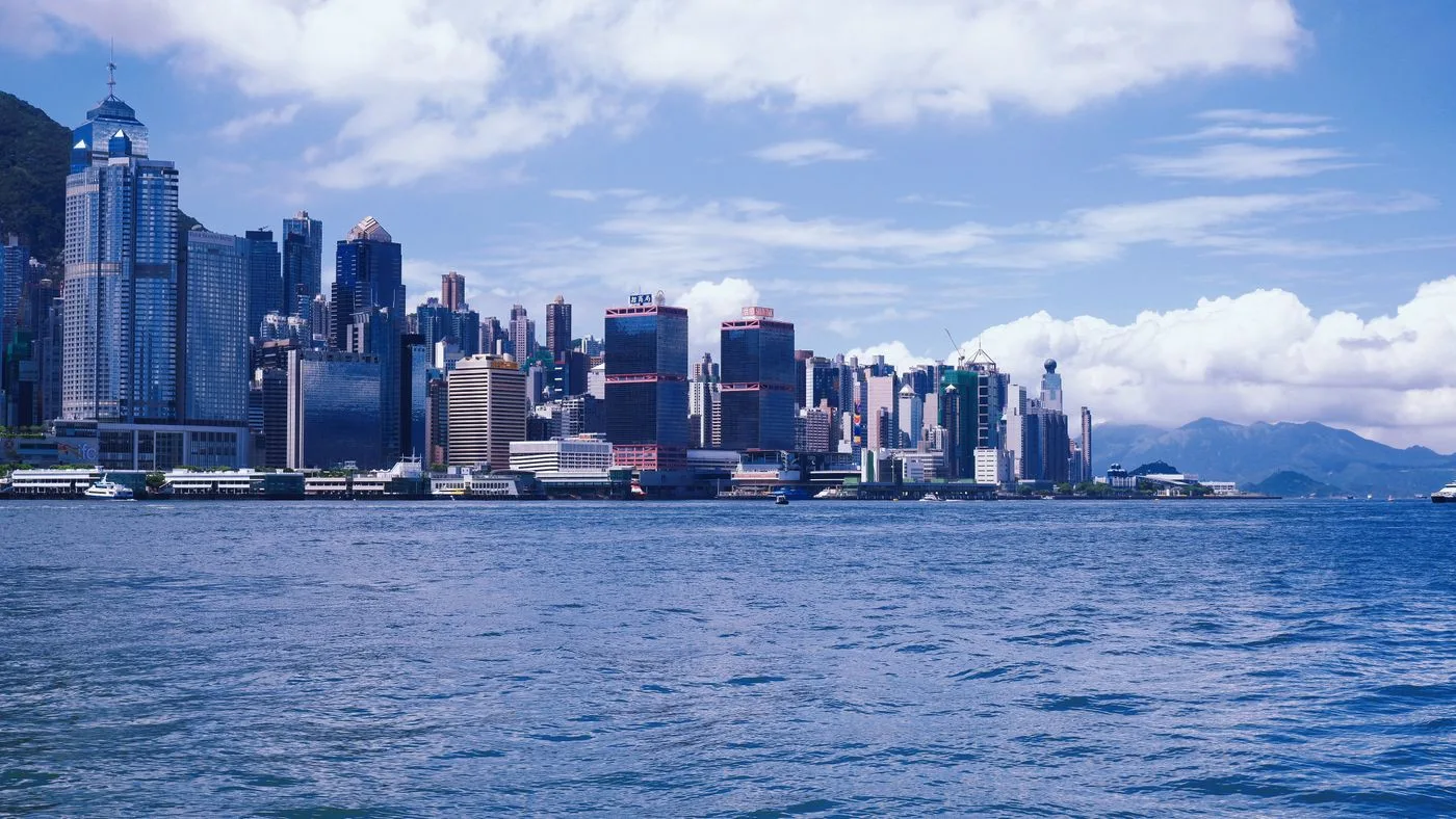 The Hong Kong Island skyline seen across the blue water of Victoria Harbour