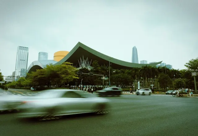 The sweeping green roof of Shenzhen Civic Center with the Futian skyline behind it