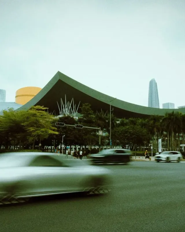 The sweeping green roof of Shenzhen Civic Center with the Futian skyline behind it
