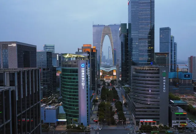 The arch-shaped Gate of the Orient rising among the modern buildings of Suzhou