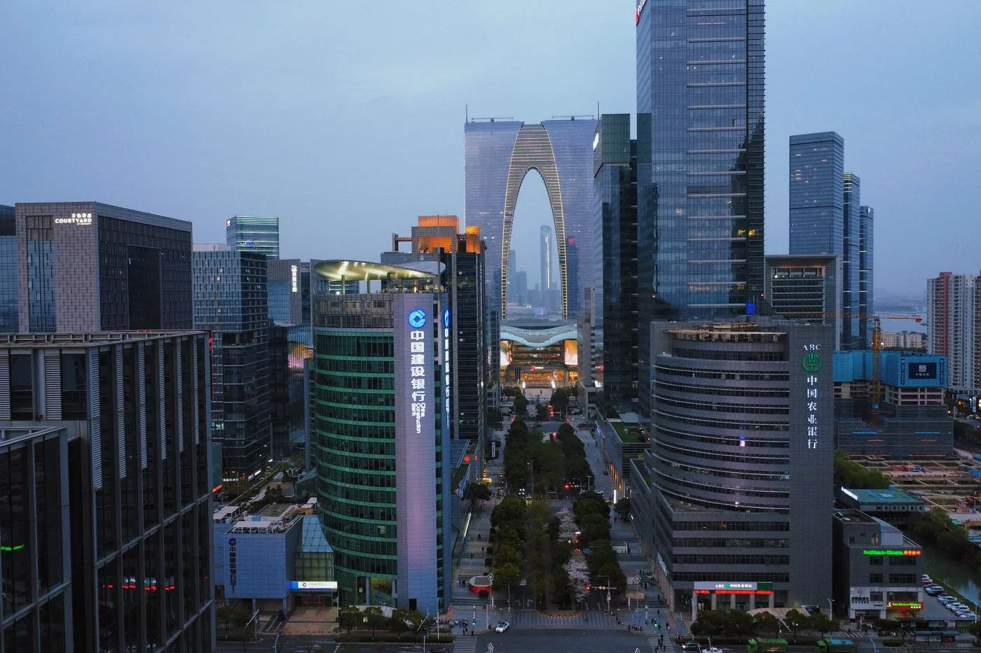 The arch-shaped Gate of the Orient rising among the modern buildings of Suzhou